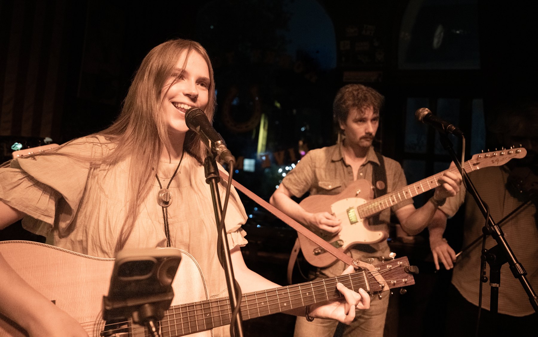 Whippoorwill singer smiling onstage at Skinny Dennis